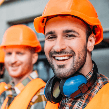 Construction workers on site wearing safety gear, supported by a construction safety app for better site safety management.