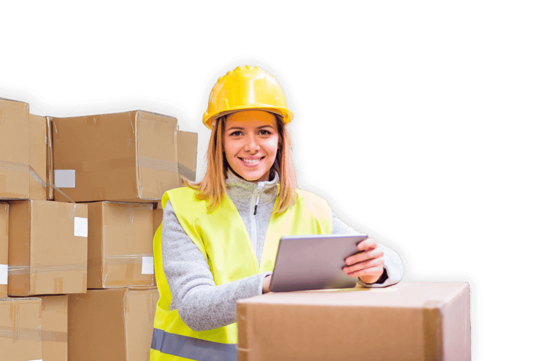 Woman in a hard hat and safety vest using a tablet near shipping boxes to watch a SiteConnect webinar.