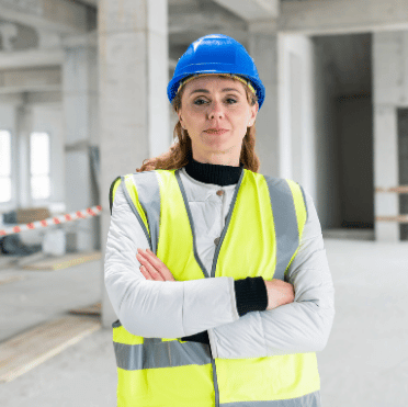 Female construction worker wearing hard hat and hi-vis vest on site, representing SWMS compliance and digital SWMS software for construction safety management.