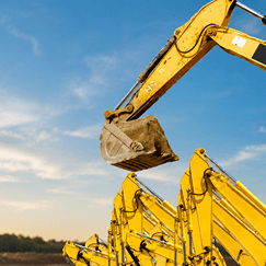 Excavators at a construction site illustrating how asset management tools help track heavy equipment, maintenance schedules and compliance.