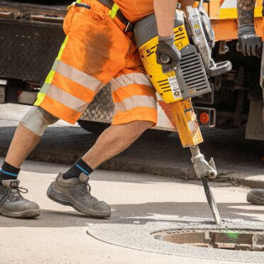 Construction worker using heavy equipment, illustrating how asset management for safety compliance helps reduce equipment risks on site.