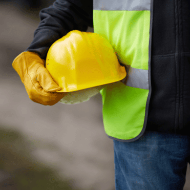 Construction worker with safety gear supporting an integrated risk management approach across multiple sites.