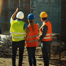 How to Run Toolbox Talks That Actually Improve Site Safety, featuring three construction workers in high-visibility PPE discussing work on site.