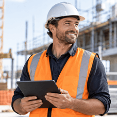 Smiling foreman contractor completing digital site induction on tablet.